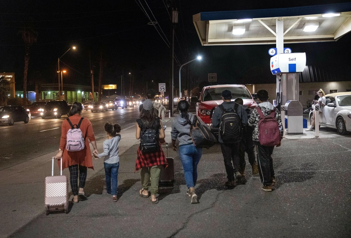 Familia migrante camina en la ciudad de Yuma, Arizona, rumbo a las oficinas de la patrulla fronteriza de EU para solicitar asilo. Foto Afp